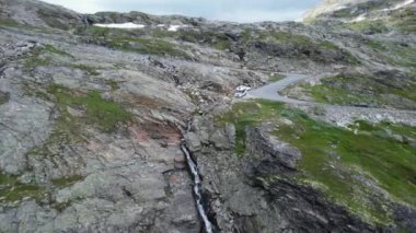 Beyaz karavanın hava görüntüsü Viraj Yolu 'nun yanındaki Manzaralı Dağ Beneği' ne park edilmiş. Norveç Peyzajı. Gezici Tema.