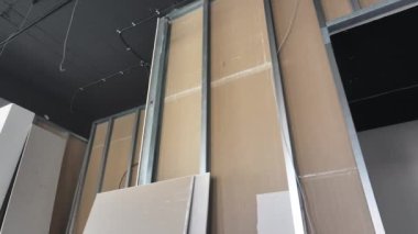 Videoda metal, alçıpan ve ahşap malzemelerin kombinasyonuyla inşa edilmiş bir duvar bulunan bir oda yer alıyor. Kamera, eşsiz mimari elementin karmaşık tasarımı ve işçiliğini vurguluyor..