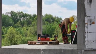 Bir inşaat işçisi aktif olarak bir inşaat sahasında inşaat işleriyle meşgul. İşçi binanın inşasına katkıda bulunmak için çeşitli görevler yerine getirirken görülüyor..
