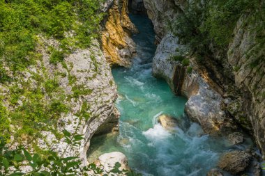 Dar bir dağ geçidinde akan turkuaz bir nehrin nefes kesici manzarası. Soca Nehri, Slovenya.