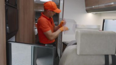RV Kiralama İşçisi Temizleme Karavanı İçi: Mutfak ve Oturma Alanı