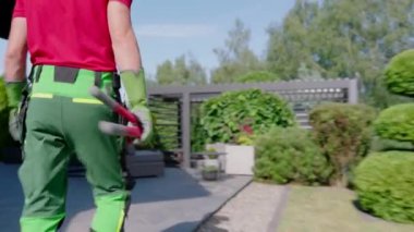 Profesyonel Bahçıvan Yeşil Pantolon ile Bahçede Yürüyor