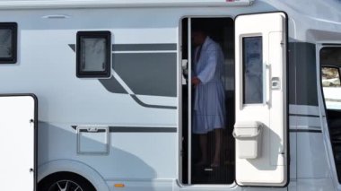 Elinde bir fincan kahveyle Bornozlu Turist Kamp Minibüsü