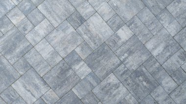 Ringa kemiği deseninde düzenlenmiş gri asfaltlı bir yüzeye yakın çekim görüntüsü desenli tasarımı ve renk değişimlerini gösterir..