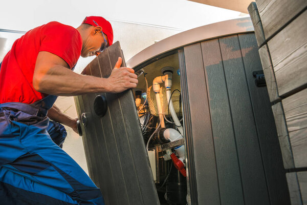 A technician inspects and maintains the internal components of a hot tub at a home, ensuring proper functionality and safety.