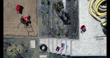 Yabani otlar ve kayalar. Bir eve kaldırım döşeme, ekme ve ekipman kurulumu da dahil olmak üzere peyzaj işleri.