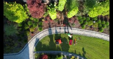 Bir hava görüntüsü, çeşitli bitki ve bahçe işçilerinin yer aldığı yemyeşil bir bahçeyi profesyonel ekipmanları ve aletleriyle yakalıyor..