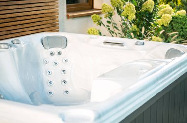 Lüks bir jakuzi, rahatlamak için mükemmel çiçekli arka planıyla açık havada durur..