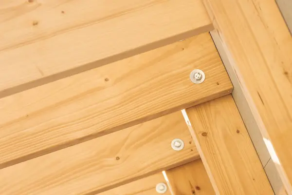 stock image Close-up view of wooden beams and fasteners showcasing quality craftsmanship in outdoor decking during daylight.