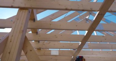 İşçiler ahşap bir çerçeve oluşturuyorlar. Yapının ilerleyişini öğleden sonra mavi gökyüzüne karşı sergiliyorlar..