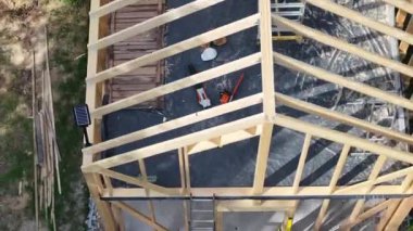 Bir konut arka bahçesinde ahşap çerçeve inşaatı, binanın yerleşim planını ve kullanılan malzemeleri vurguluyor..