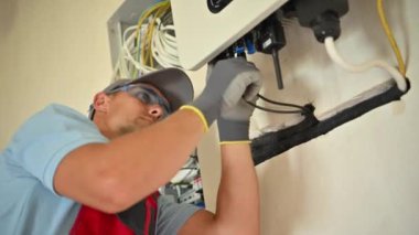 Yetenekli bir elektrikçi, bir evdeki güneş panelleri sistemi üzerinde özenle çalışarak her şeyin düzgün ve güvenli bir şekilde çalıştığından emin olur..