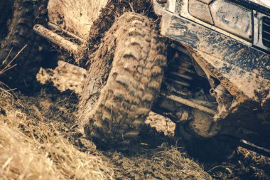 Çamurlu zemin üzerinde mücadele eden, off-road yeteneklerini sergileyen bir araç maceralı bir gezinti sırasında zorlu arazilerle mücadele ediyor..