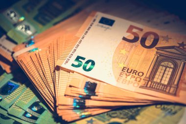 Elli avroluk banknotlar özgün renklerini ve tasarımlarını koyu bir arkaplana karşı sergileyerek çarpıcı bir görsel karşıtlık yaratıyor..