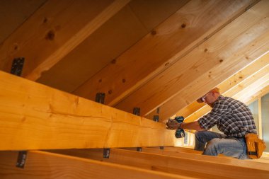 Bir marangoz ustalıkla tavan arasına ahşap kirişler yerleştirir. Tadilat sırasında işçilik ve detaylara dikkat çeker..