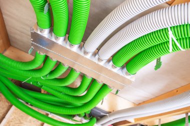 Parlak yeşil ve beyaz kanallar, inşaat halindeki çağdaş bir binanın tavanında düzgünce düzenlenir..