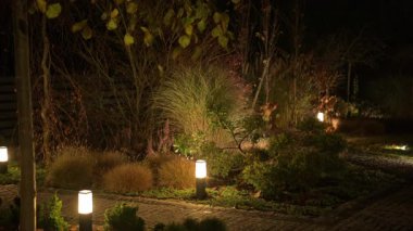 Yumuşak ışıklandırma bahçenin sakin ve davetkar atmosferini arttırır. Bereketli bitkiler ve bakımlı yollar dinlenmek için mükemmel sakin bir ortam yaratır..