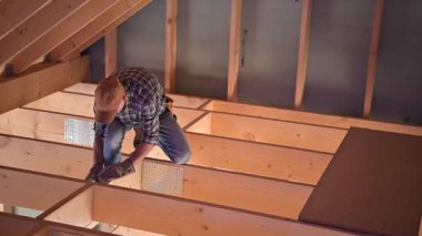 Becerikli bir işçi, konut tadilatında çatıyı çerçevelemeye odaklanıyor. Ahşap kirişleri dikkatlice yerleştirirken detaylara çok dikkat edilir. Süreç boyunca güvenlik tedbirleri alınır.