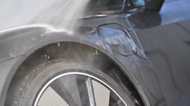 Su püskürtüleri kiri ve kiri püskürttükçe lastik alanının eksiksiz temizlenmesi gerçekleşiyor. Süreçte öğleden sonra gerçekleştirilen etkin bir araba temizleme yöntemi gösteriliyor.