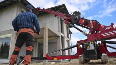 İnşaat İşçisi Gün Işığı Altında Kırsal Alandaki Yeni Binanın Pencerelerini Yüklemek İçin Pencere Kaldırma Kullanıyor