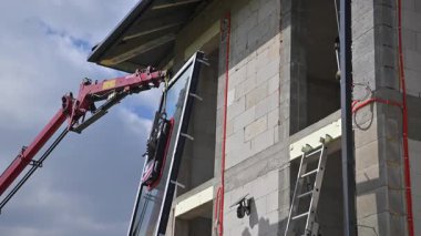 İnşaat işçileri öğleden sonra Bulutlu Gökyüzü Altındaki Bir Binanın Üzerine Büyük Cam Paneller Kurdular