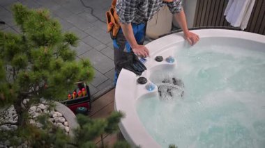 Gündüz vakti Residential Backyard 'da jakuzide bakım yapan kişi