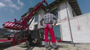 İnşaat İşçisi, Varoş Bölgesinde Yapısal Destek ve Verimliliği Artırmaya Odaklanma Projesi için Pencereler Turna Malzemesi Kullanıyor