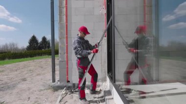 İnşaat işçisi Sunny Afternoon sırasında banliyödeki Modern İnşaat Alanına Büyük Pencere Kuruyor