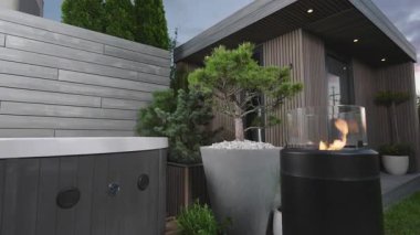 Modern Jakuzi ve Şık Alev Özelliklerinin Sunset 'te Yeşilliğin Ortasındaki Zarif Arka Bahçe Vahası