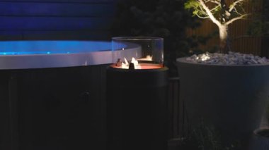 Sıcak bir akşamın keyfini çıkarıyorum. Ateşin yanında ve sıcak bir havada jakuzinin keyfini çıkarıyorum.