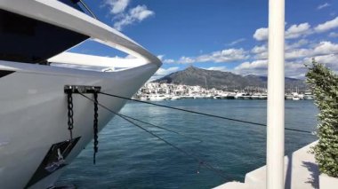 Lüks Yat güneşli bir günde Porto Banus Marina 'da Manzaralı Dağ Arkaplanı ile kenetlendi