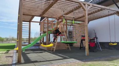 Çocuk Oyun Zamanı için Salıncak, Kaydırak ve Tırmanma Yapıları içeren Arka Bahçe İnşaatı