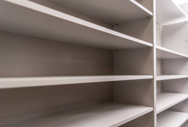 Modern raf ünitesi, minimalist bir yaşam alanında kitap, dekor ve kişisel eşyaları düzenlemek için mükemmel, parlak tasarım ve boş raflara sahiptir..