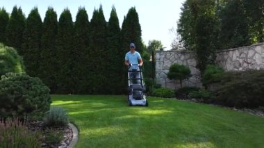 Rahatlatıcı bir öğleden sonranın tadını çıkarın. Birileri çimlerini biçiyor, verimli çimenlik tekniklerini sergiliyor. Yeşillik ve peyzaj ortamları arasında..