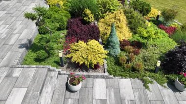 Yeşillik ve renkli bitkilerin ahenkli bir şekilde düzenlendiği çarpıcı bir bahçe keşfedin. Dış mekanı geliştiren çağdaş taş kaldırımların keyfini çıkarın..