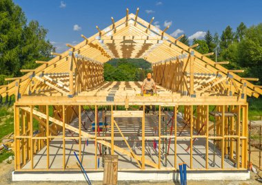 Beyaz marangoz 40 'larında aktif olarak bir ev için ahşap iskelet inşa etmekle meşgul.