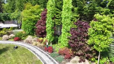 Güneşli bir öğleden sonra, titizlikle tasarlanmış açık havada yemyeşil ve renkli bitkilerle çarpıcı bir bahçe dönüşümü yaşayın..