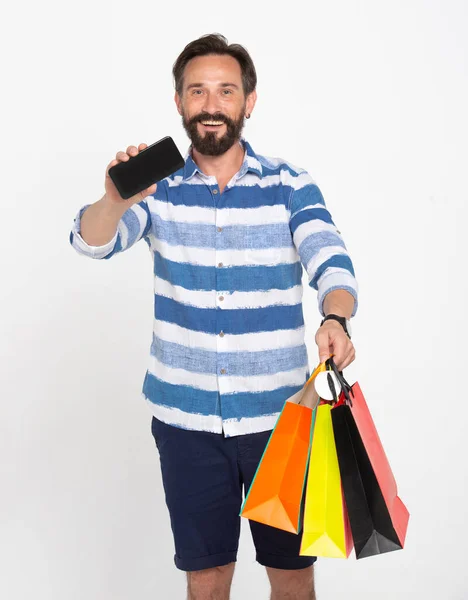 Vousatý Muž Drží Nákupní Tašky Zatímco Show Smartphone Černou Obrazovkou — Stock fotografie