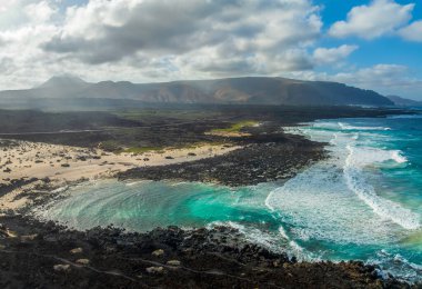 Lanzarote, Kanarya Adaları, İspanya 'daki Caleta del Mojon Blanco üzerinde turkuaz okyanus suyuyla manzara
