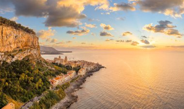 Günbatımında Sicilya, Cefalu 'nun tarihi mimarisi, çarpıcı kıyı şeridi ve Akdeniz cazibesini gösteren hava manzarası.