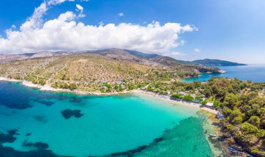 Aerial view of Aliki Beach in Thassos, Greece, featuring turquoise waters, pine-covered hills, and a tranquil Mediterranean setting perfect for a peaceful vacation. clipart