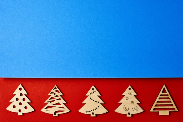 New Years red and blue card, with a pattern of Christmas trees. Christmas background for inscriptions. Minimalistic Christmas card. Frame, banner. Christmas trees top view. Winter vacation.