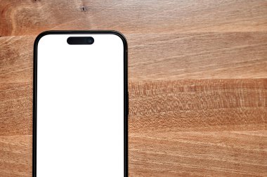 Newcastle, UK, January 8, 2023: iPhone 14 pro max with a white blank screen lying on a wooden surface. iPhone mockup.
