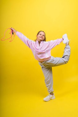 Adorable female child with skipping rope jumping in a studio