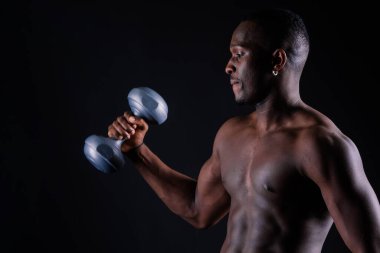 Kendine güvenen genç adam gömleksiz portre siyah arka plan aptal-bell ile eğitim.