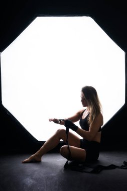 Strong sportswoman in boxing gloves prepared high kick. Isolated on a white, red, yellow background
