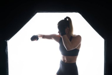 Woman do a high kick, tae-bo. Athletic fit female with perfect body kick air, punching with legs