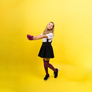 Happy schoolgirl with colored pencils and pencil case in hand