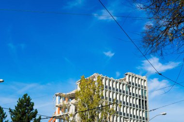 Background of process of demolition of a building. Excavator breaking old house.