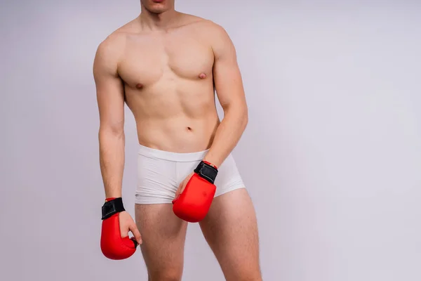 白色背景和白色裤子运动型健美运动员拳击手套 — 图库照片